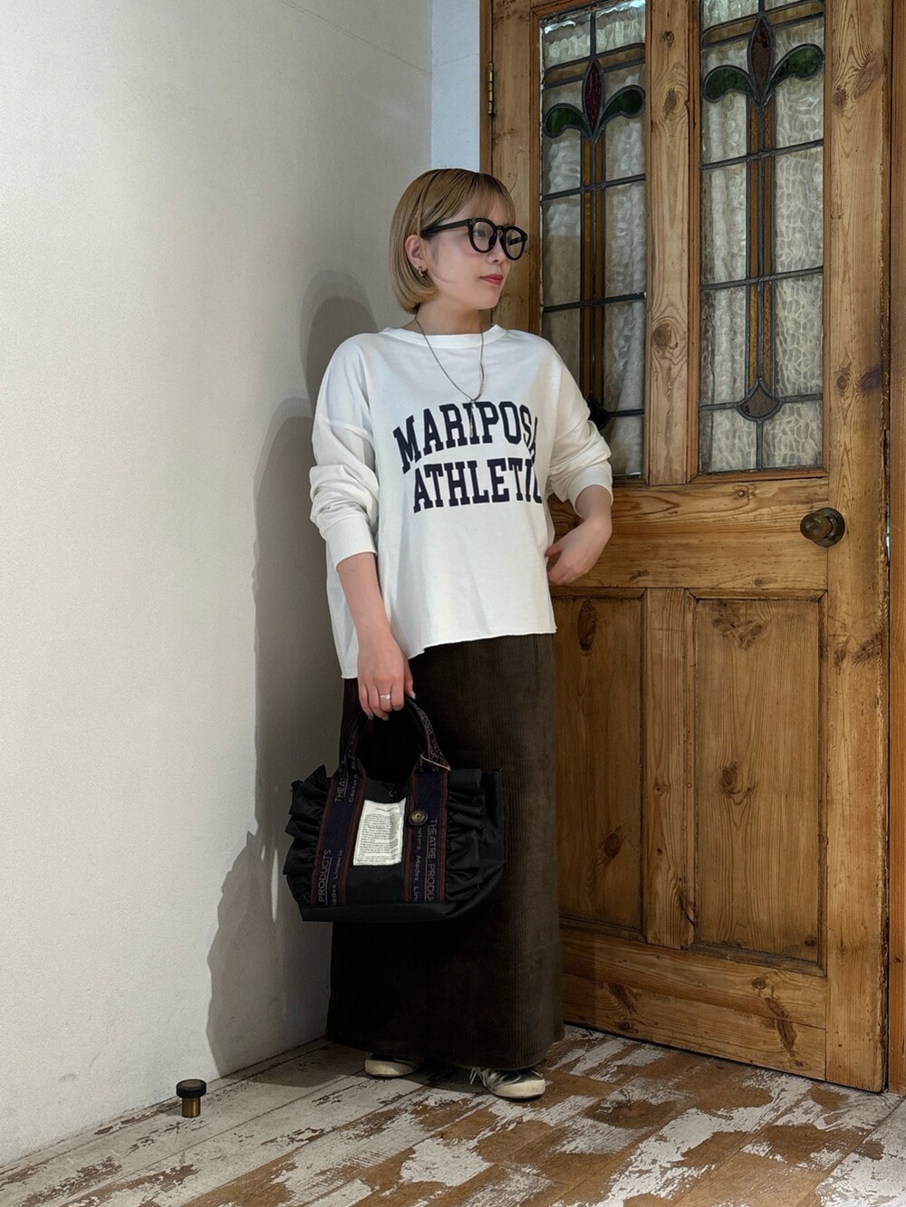 グリーン系のスカート、ホワイト系のTシャツ/カットソー、シルバー系のスニーカーを着用したレディースの夏コーディネートの3枚目の写真