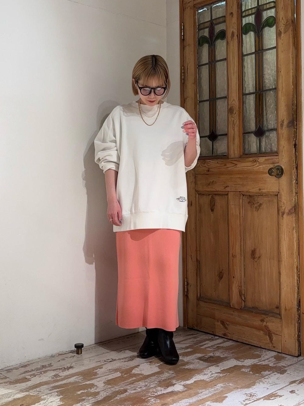 ピンク系のスカート、ホワイト系のスウェットを着用したレディースの春コーディネートの3枚目の写真
