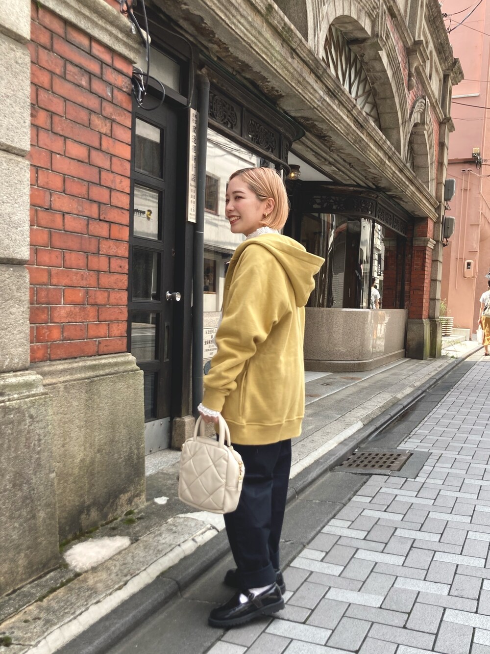 イエロー系のカーディガン/ボレロ、ブラック系のその他パンツ、ホワイト系のシャツ/ブラウスを着用したレディースの夏コーディネートの2枚目の写真