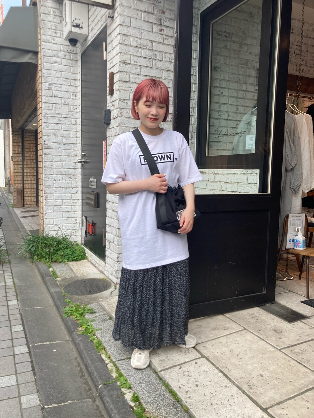 ホワイト系のTシャツ/カットソー、ブラック系のショルダーバッグ、ブラック系のスカートを着用したレディースの春コーディネートの4枚目の写真