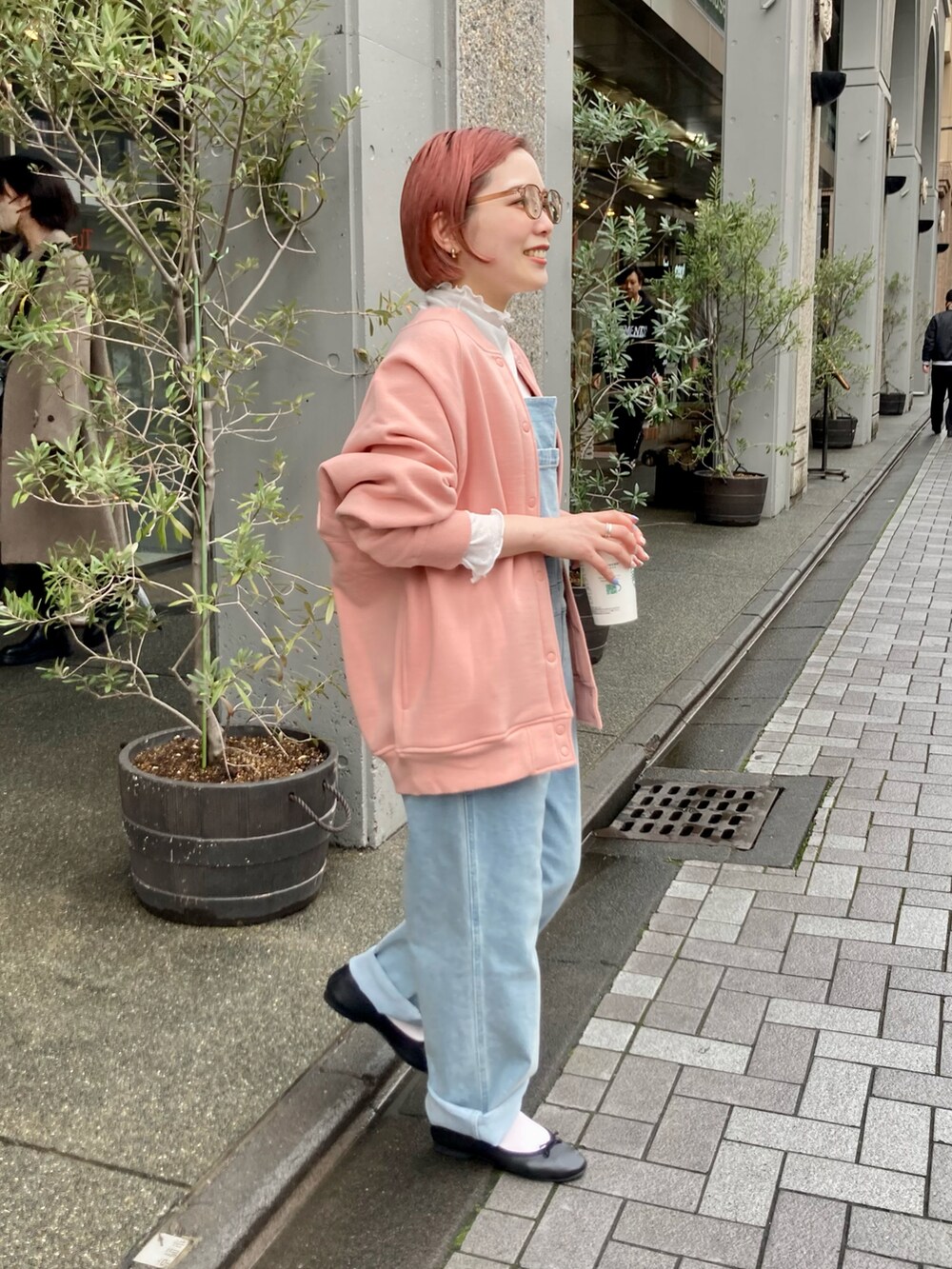 ピンク系のカーディガン/ボレロ、ブルー系のサロペット/オーバーオール、ホワイト系のTシャツ/カットソーを着用したレディースの冬コーディネートの2枚目の写真