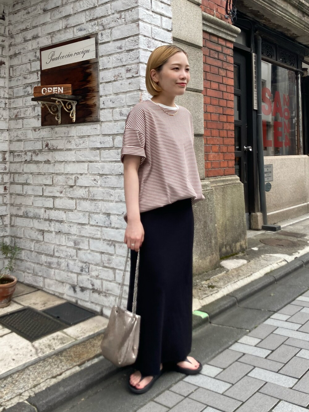 ブラック系のサンダル、ブラック系のスカート、ブラウン系のTシャツ/カットソーを着用したレディースの夏コーディネートの3枚目の写真