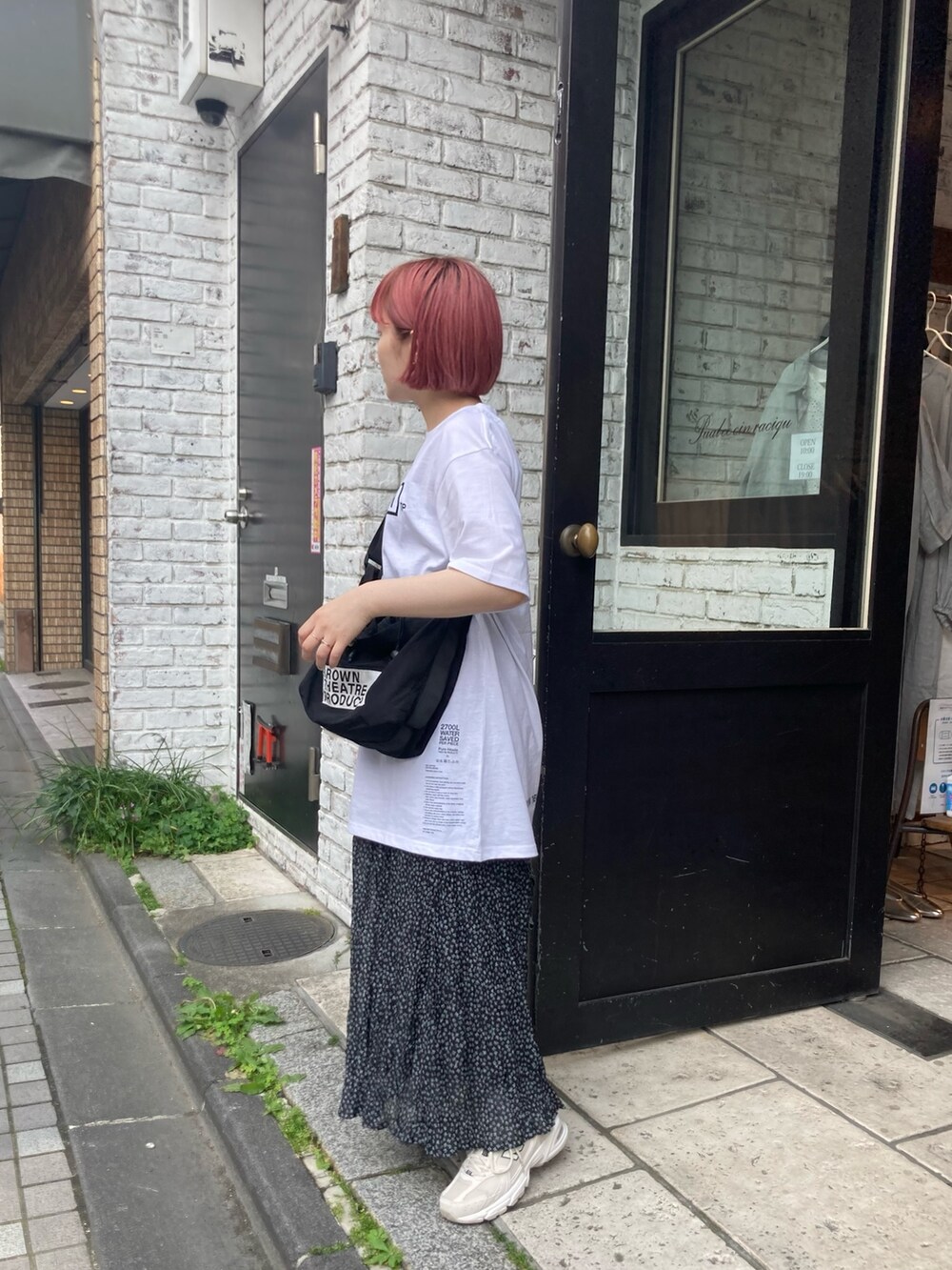 ホワイト系のTシャツ/カットソー、ブラック系のショルダーバッグ、ブラック系のスカートを着用したレディースの春コーディネートの2枚目の写真