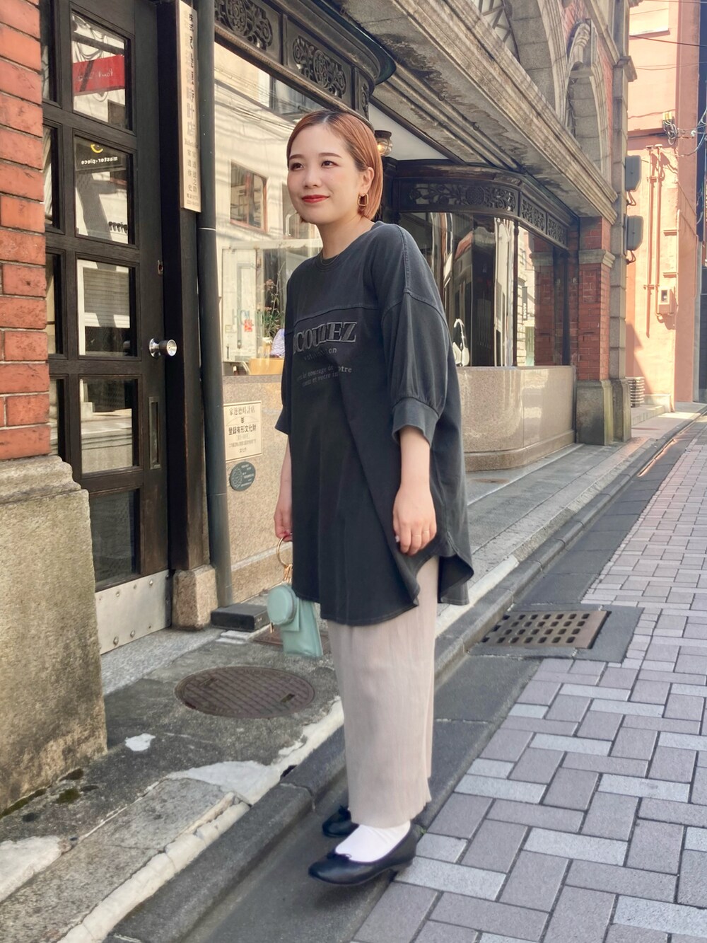 ベージュ系のスカート、ブルー系のショルダーバッグ、グレー系のTシャツ/カットソーを着用したレディースの夏コーディネートの4枚目の写真