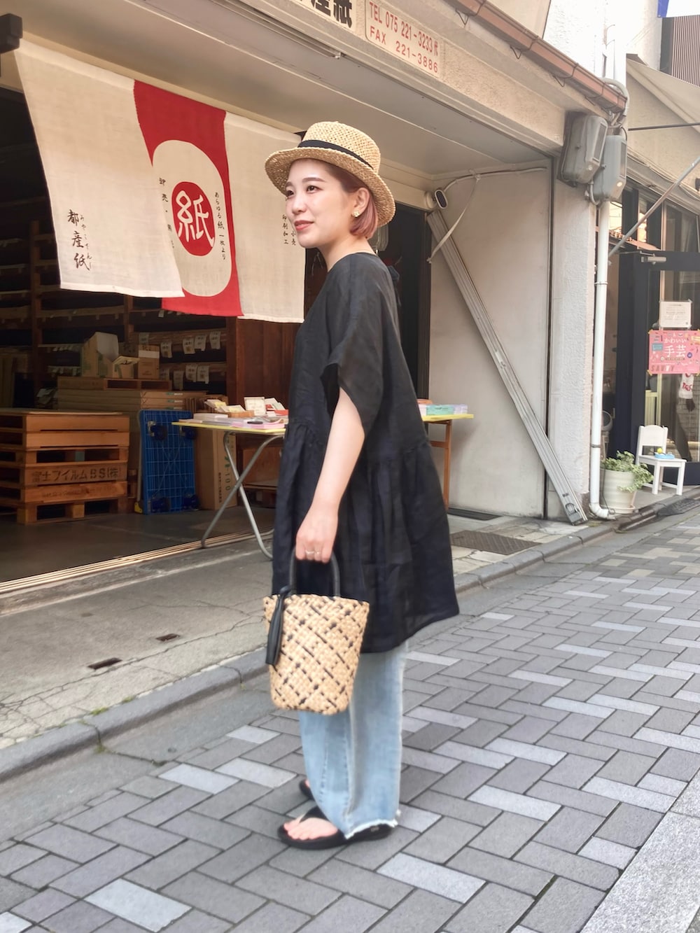 ブラック系のシャツ/ブラウス、ブルー系のデニムパンツ、ブラック系のサンダルを着用したレディースの夏コーディネートの3枚目の写真