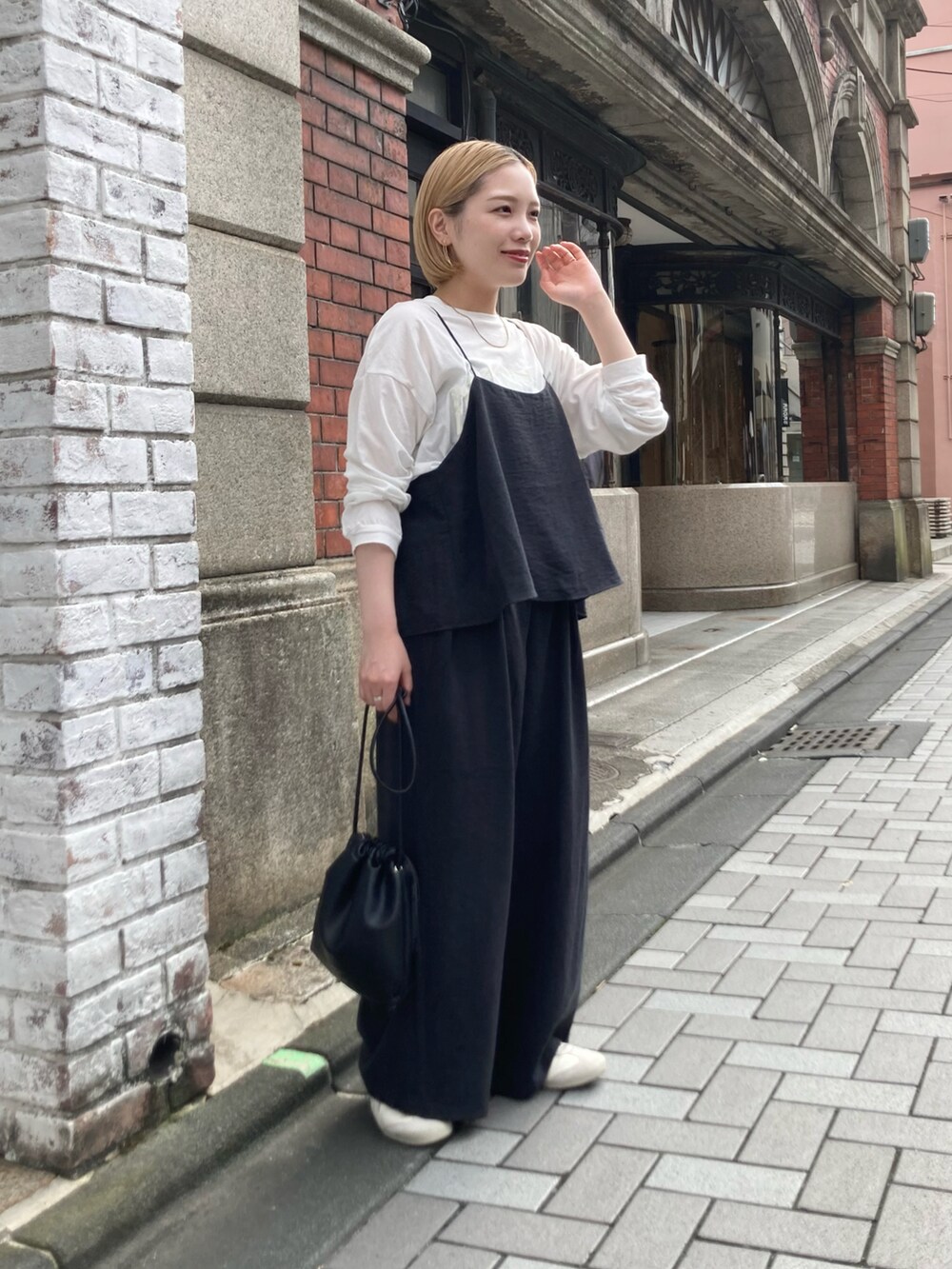 ブラック系のショルダーバッグ、ブラック系のつなぎ/オールインワン、ホワイト系のTシャツ/カットソーを着用したレディースの秋コーディネートの3枚目の写真