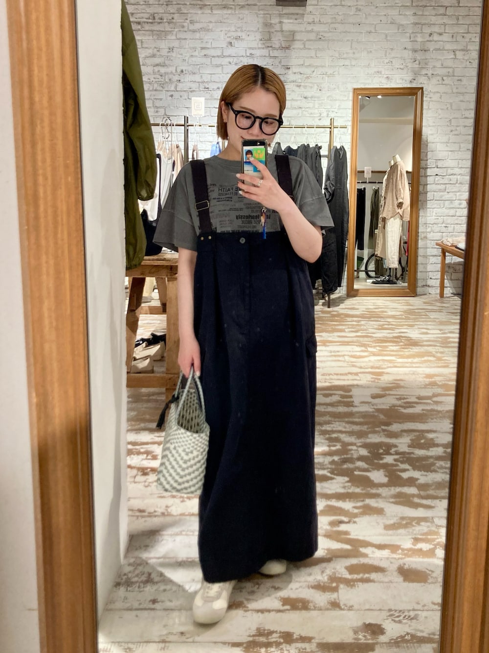 ベージュ系のスニーカー、ブラック系のスカート、グレー系のTシャツ/カットソーを着用したレディースの春コーディネートの3枚目の写真