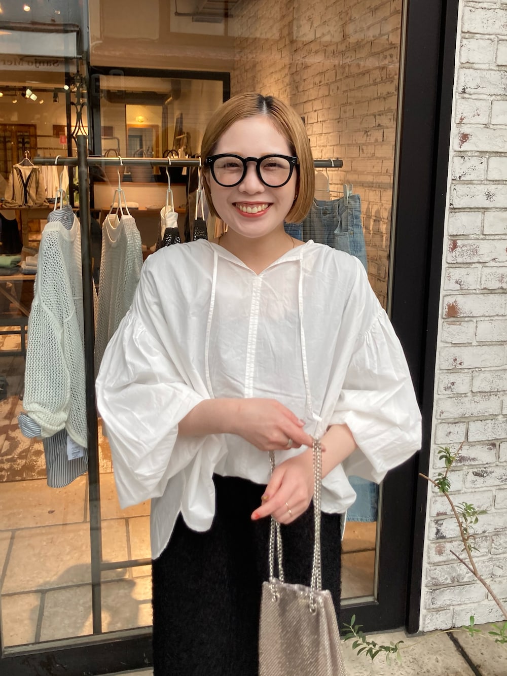 ブラック系のブーツ、ブラック系のスカート、ホワイト系のシャツ/ブラウスを着用したレディースの春コーディネートの4枚目の写真