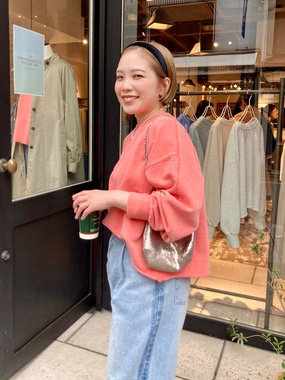 ブラック系のブーツ、ブルー系のデニムパンツ、オレンジ系のスウェットを着用したレディースの冬コーディネートの4枚目の写真