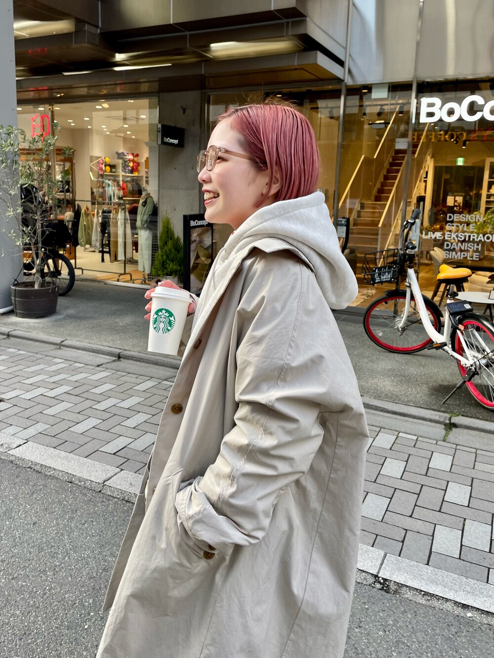 グレー系のパーカー、ブルー系のデニムパンツ、ブラック系のショルダーバッグを着用したレディースの冬コーディネートの4枚目の写真