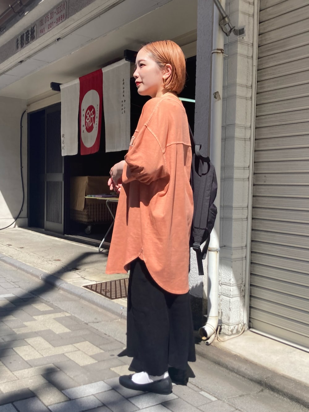 ブラック系のスカート、オレンジ系のTシャツ/カットソー、オレンジ系のTシャツ/カットソーを着用したレディースの秋コーディネートの4枚目の写真