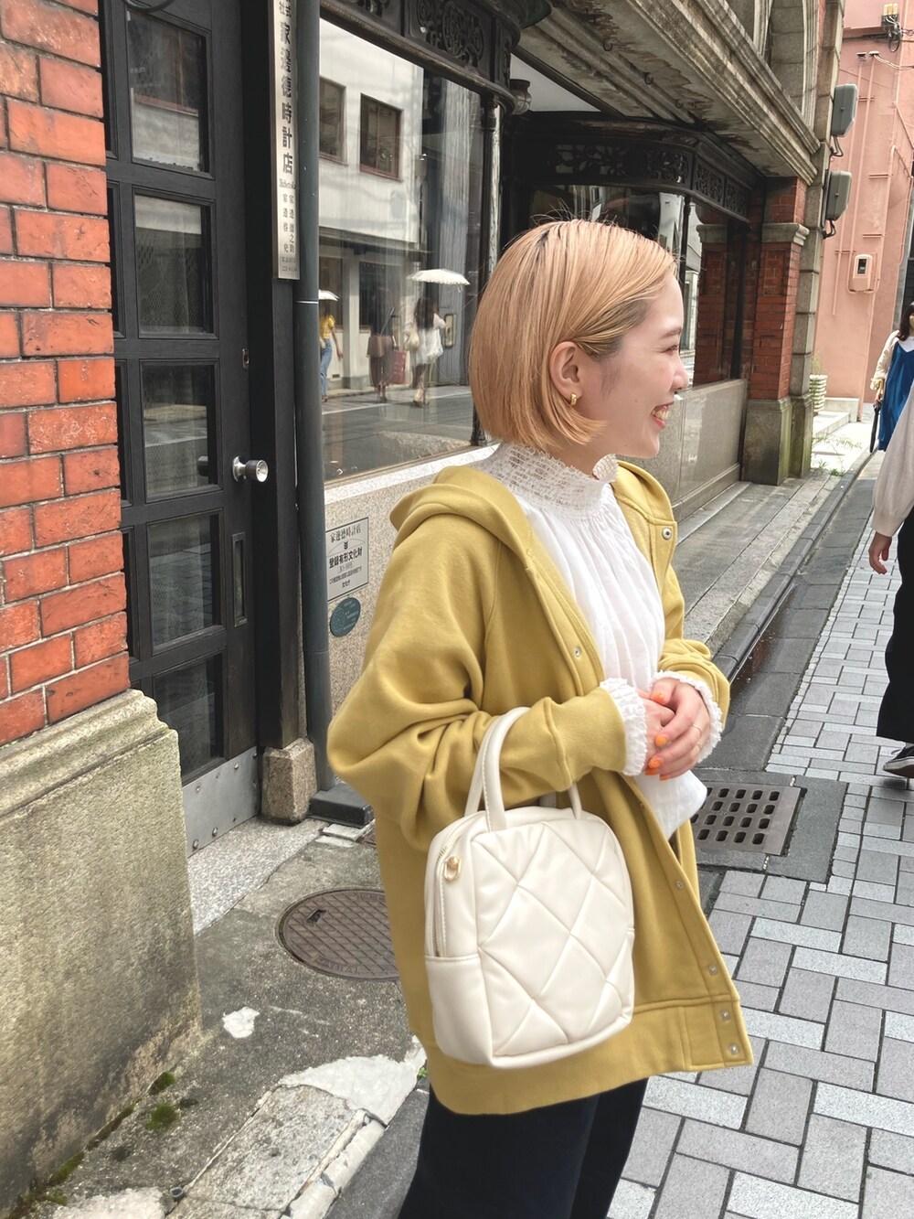 イエロー系のカーディガン/ボレロ、ブラック系のその他パンツ、ホワイト系のシャツ/ブラウスを着用したレディースの夏コーディネートの5枚目の写真