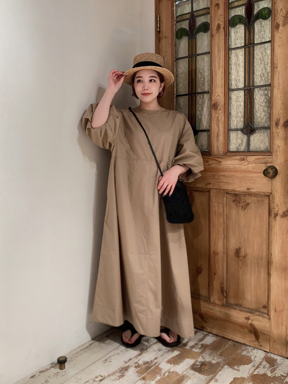 ベージュ系のワンピース、ブラック系のショルダーバッグ、ブラック系のサンダルを着用したレディースの夏コーディネートの4枚目の写真