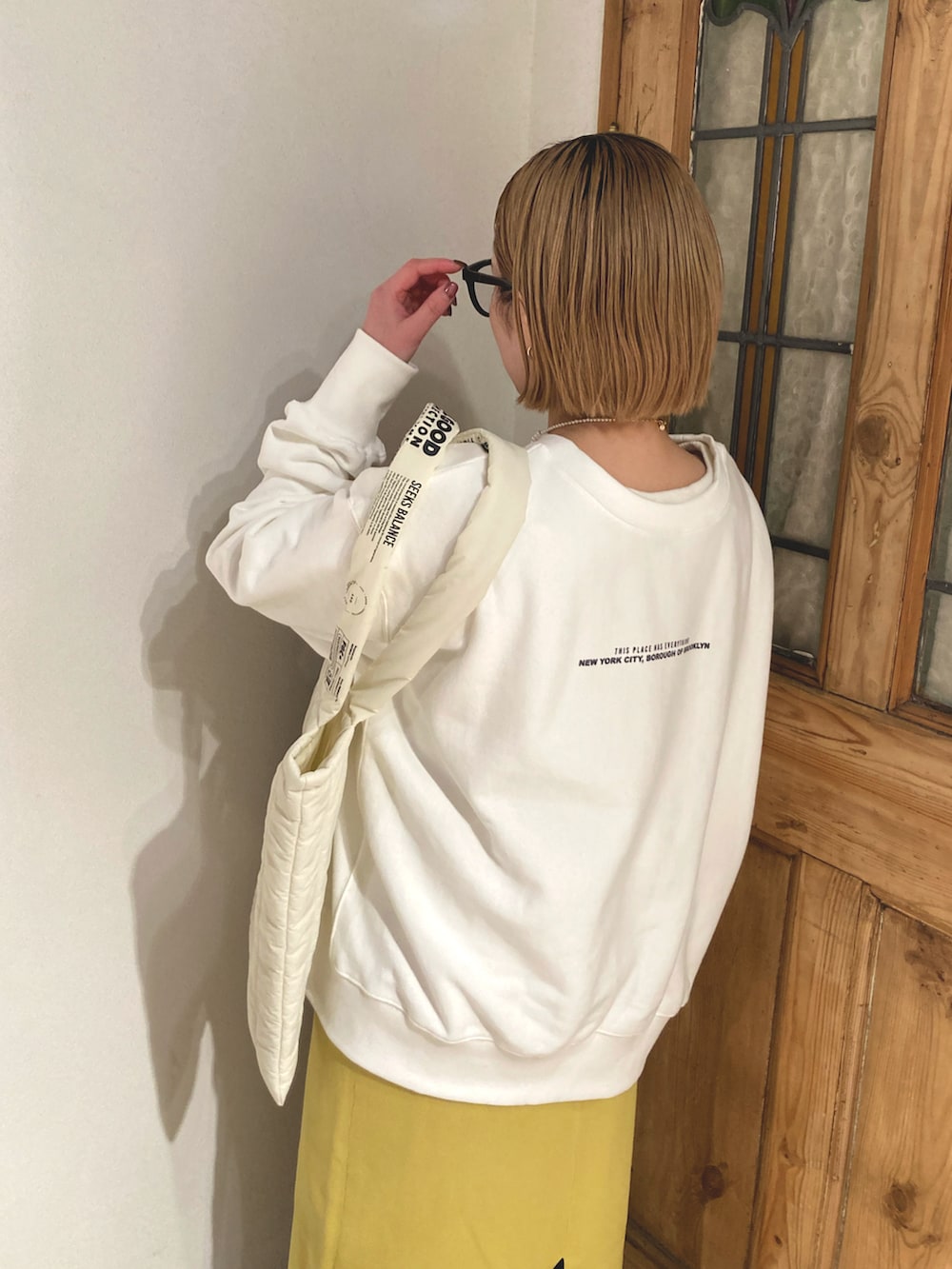 ブラック系のブーツ、イエロー系のスカート、ホワイト系のスウェットを着用したレディースの冬コーディネートの5枚目の写真