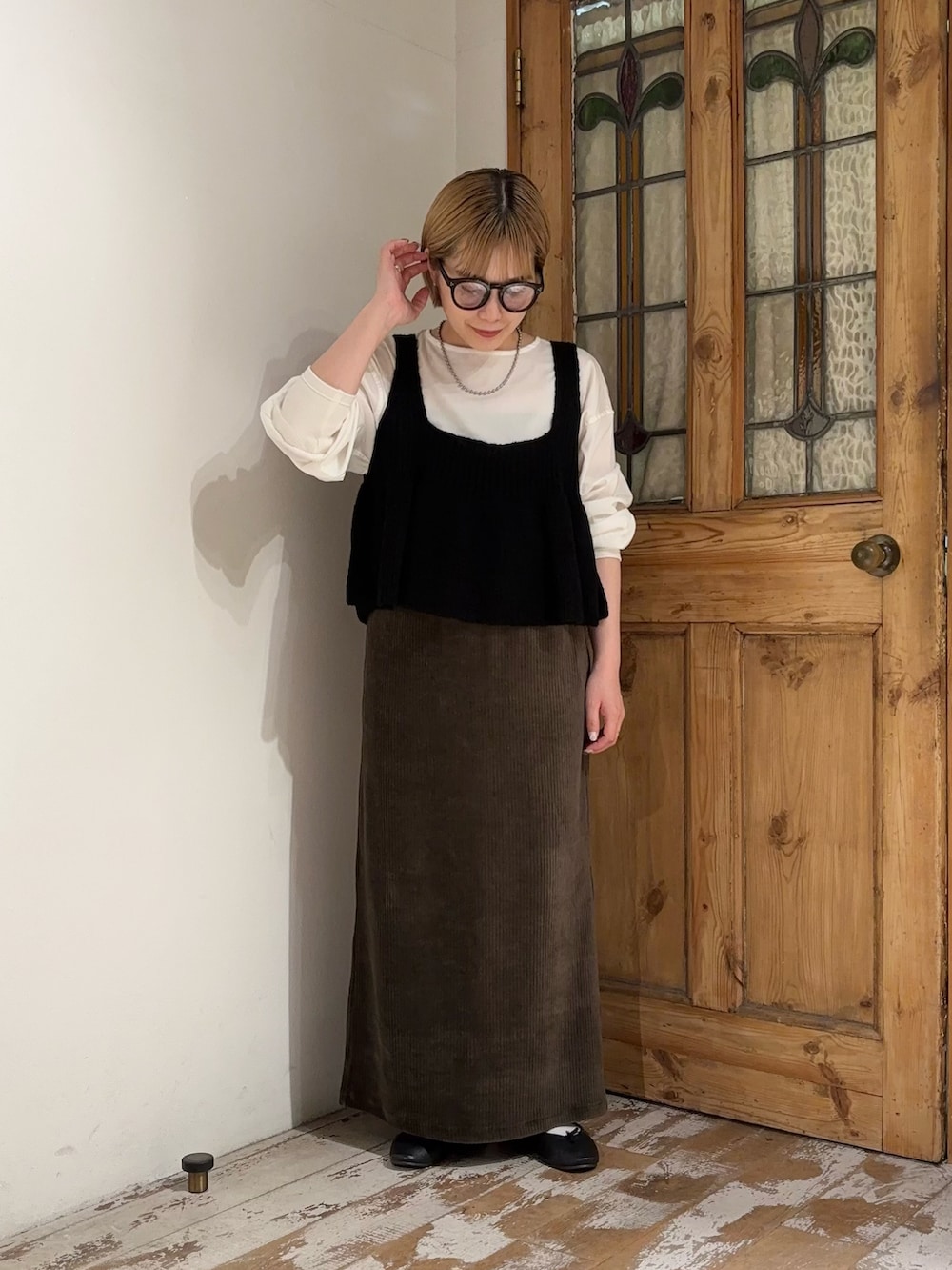 グリーン系のスカート、ブラック系のベスト、ホワイト系のシャツ/ブラウスを着用したレディースの夏コーディネートの3枚目の写真