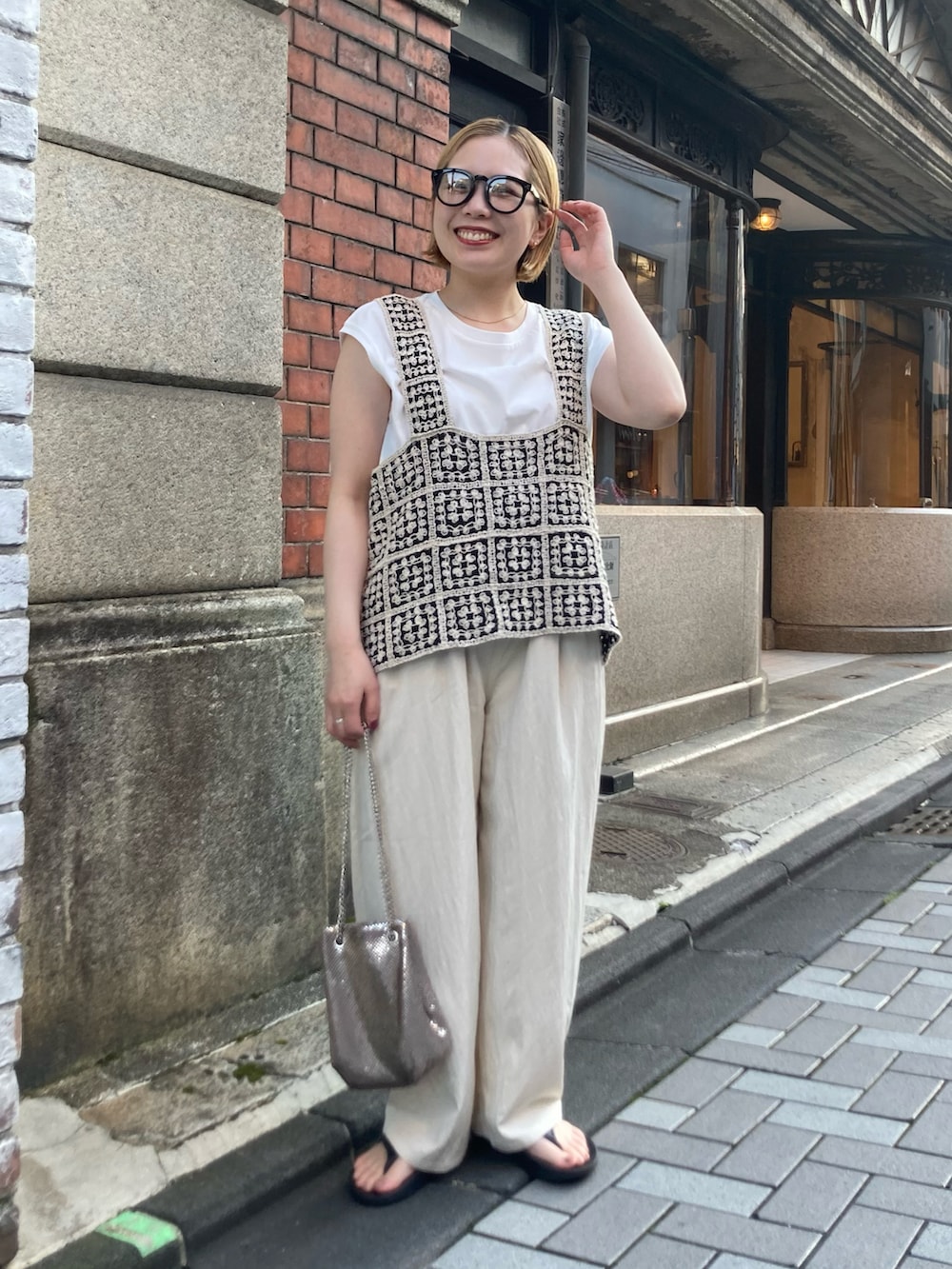 ゴールド系のショルダーバッグ、ブラック系のサンダル、その他のベストを着用したレディースの夏コーディネートの2枚目の写真