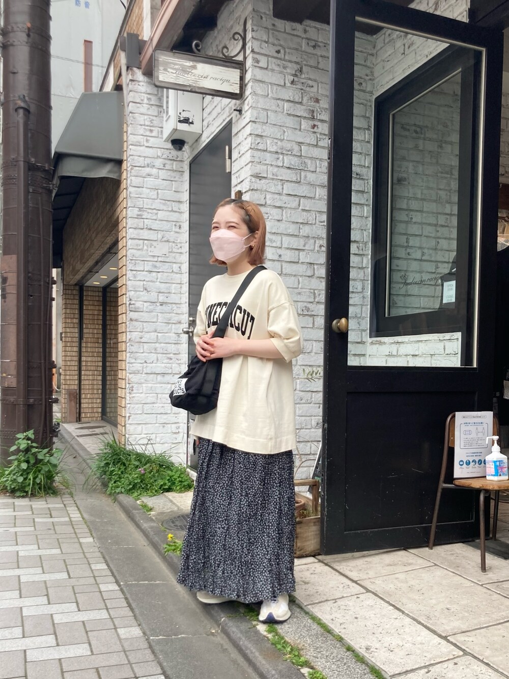 ホワイト系のTシャツ/カットソー、ブラック系のショルダーバッグ、ブラック系のスカートを着用したレディースの春コーディネートの2枚目の写真