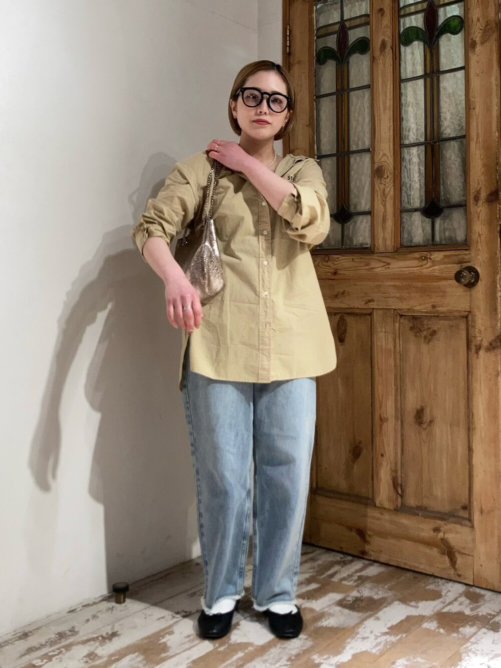 ゴールド系のショルダーバッグ、ブルー系のデニムパンツ、イエロー系のシャツ/ブラウスを着用したレディースの春コーディネートの3枚目の写真