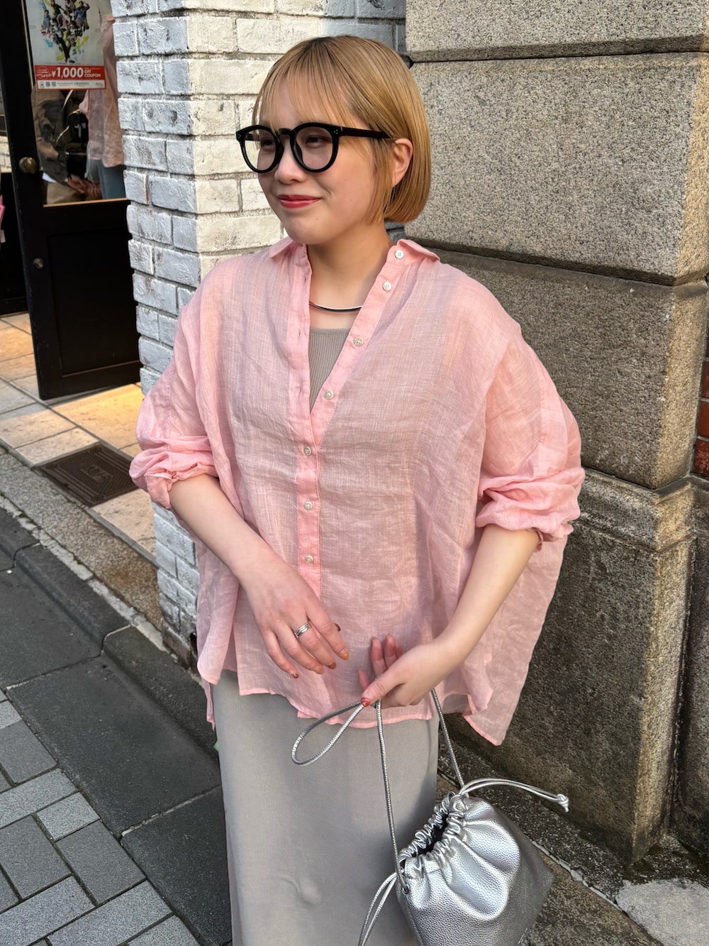 ピンク系のシャツ/ブラウス、グレー系のスカート、シルバー系のショルダーバッグを着用したレディースの春コーディネートの5枚目の写真