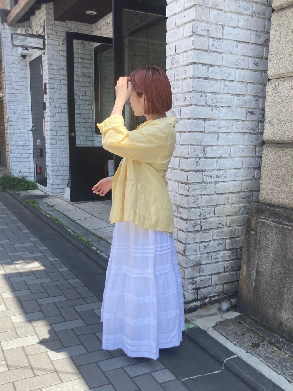 イエロー系のテーラードジャケット、ホワイト系のTシャツ/カットソー、ホワイト系のスカートを着用したレディースの夏コーディネートの3枚目の写真