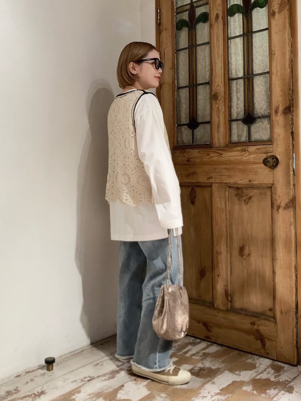 ブルー系のデニムパンツ、ゴールド系のショルダーバッグ、その他のトップスを着用したレディースの春コーディネートの4枚目の写真