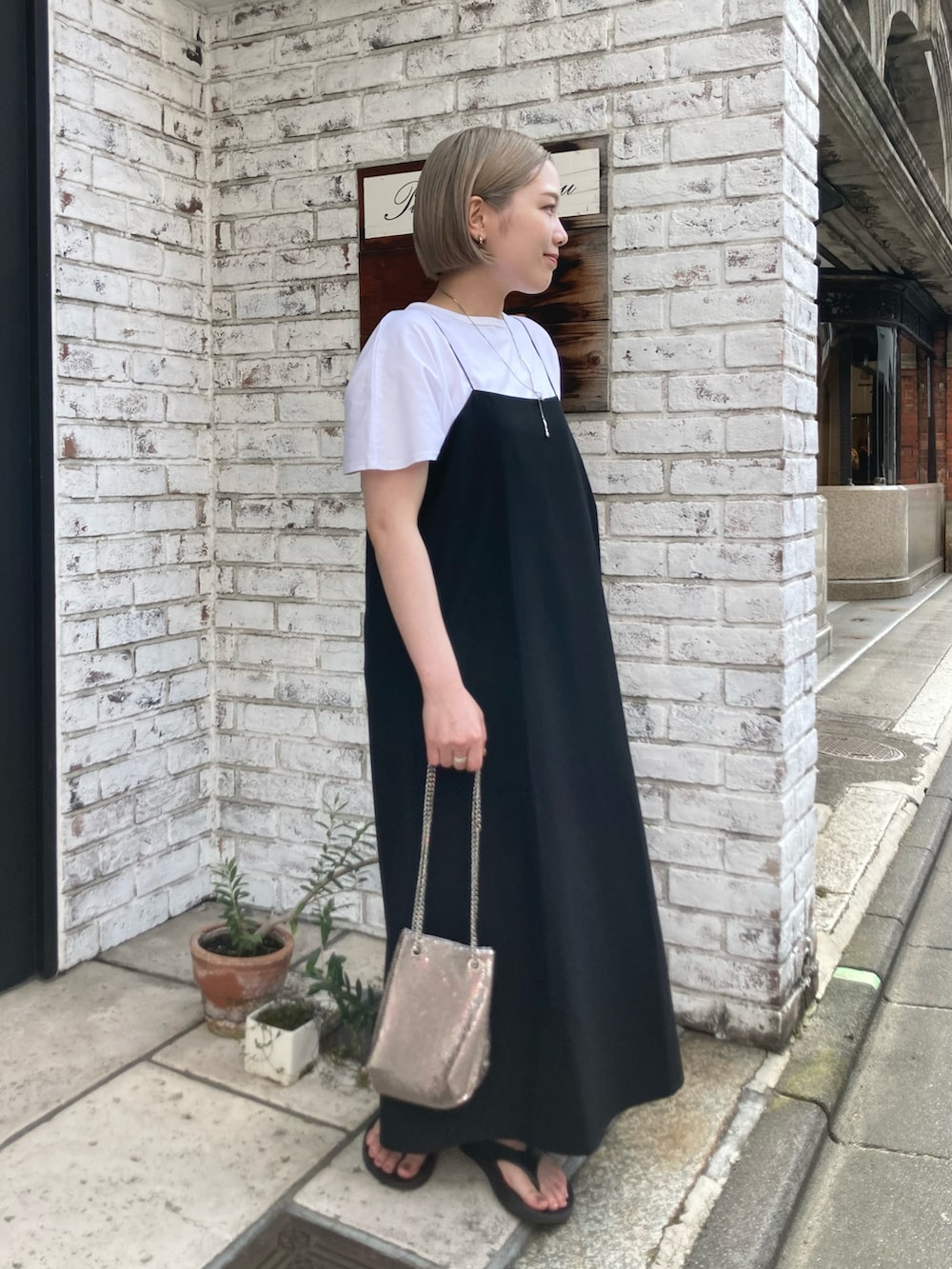 ブラック系のワンピース、シルバー系のネックレスを着用したレディースの夏コーディネートの2枚目の写真