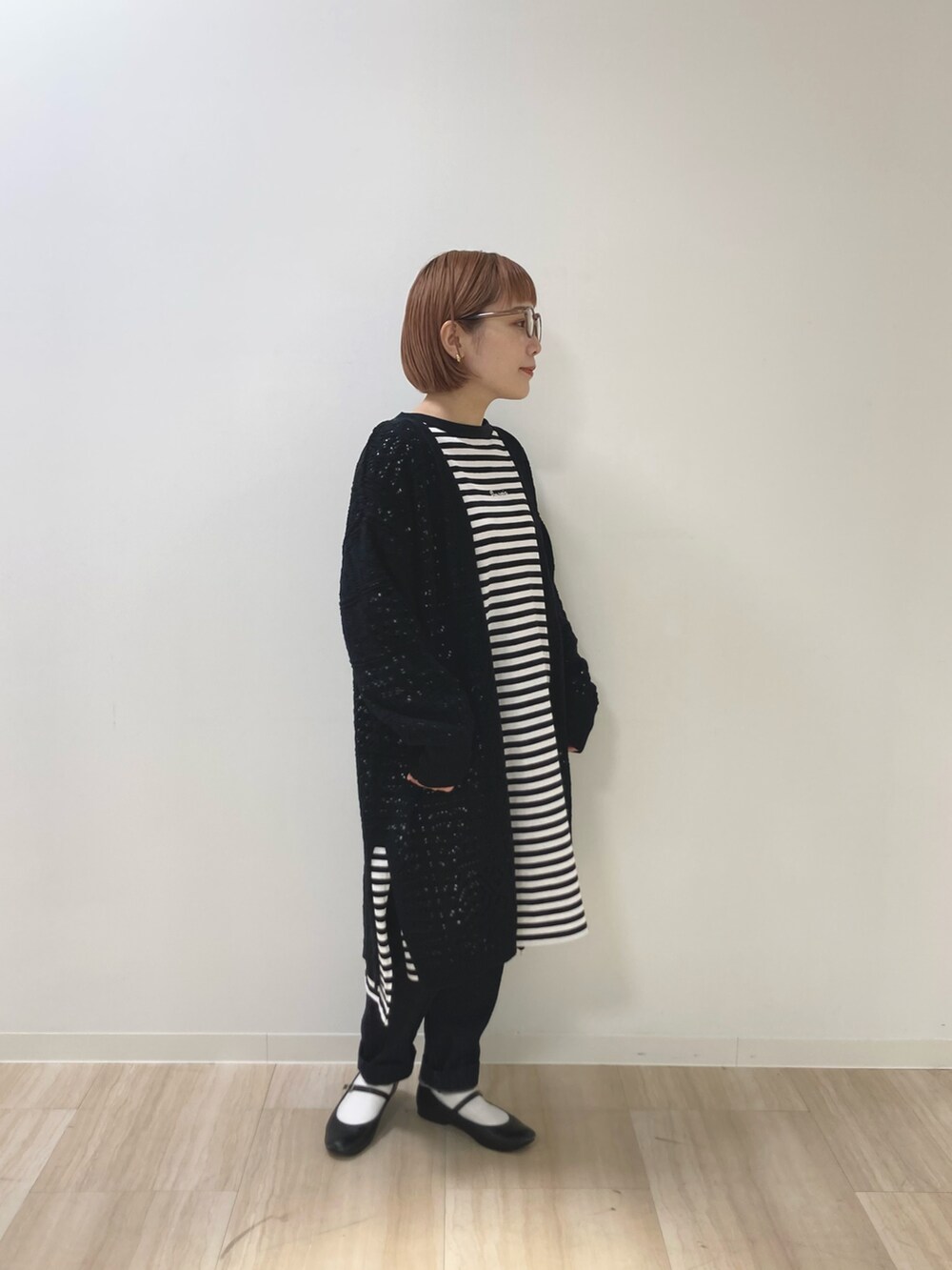 ブラック系のカーディガン/ボレロ、ホワイト系のTシャツ/カットソー、ブルー系のデニムパンツを着用したレディースの春コーディネートの2枚目の写真