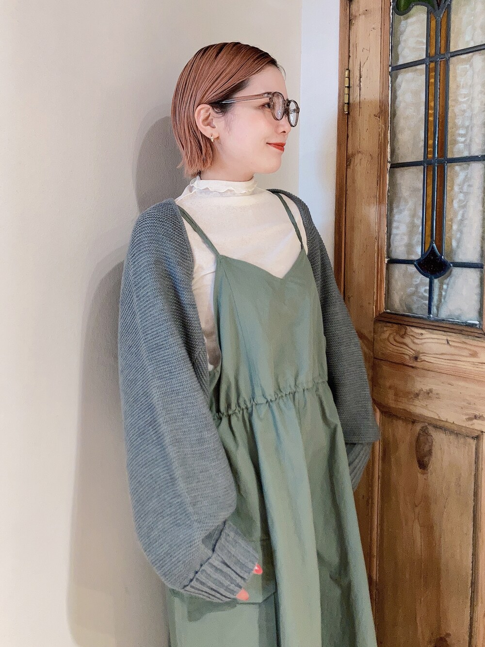 グリーン系のワンピース、ホワイト系のTシャツ/カットソー、グレー系のカーディガン/ボレロを着用したレディースの春コーディネートの5枚目の写真