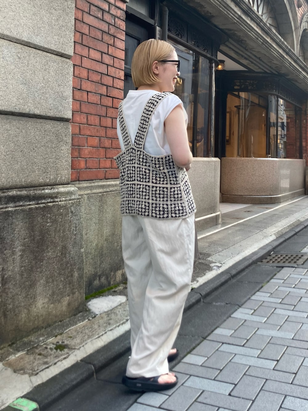 ゴールド系のショルダーバッグ、ブラック系のサンダル、その他のベストを着用したレディースの夏コーディネートの4枚目の写真