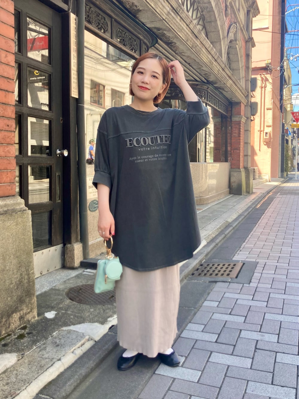 ベージュ系のスカート、ブルー系のショルダーバッグ、グレー系のTシャツ/カットソーを着用したレディースの夏コーディネートの2枚目の写真