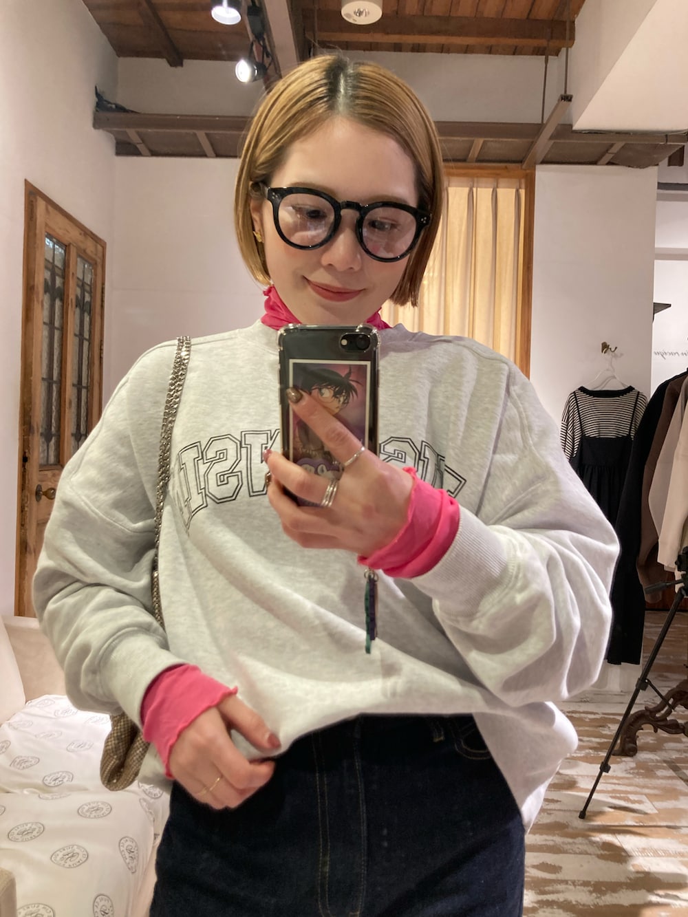 ゴールド系のショルダーバッグ、グレー系のスウェット、ピンク系のTシャツ/カットソーを着用したレディースの冬コーディネートの2枚目の写真