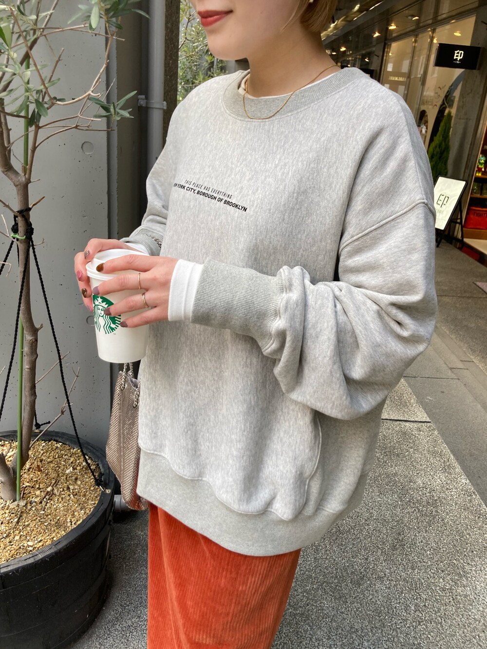 ブラック系のブーツ、オレンジ系のスカート、オレンジ系のスカートを着用したレディースの冬コーディネートの3枚目の写真