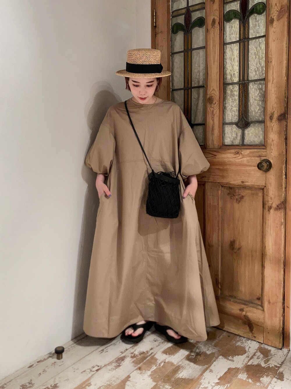 ベージュ系のワンピース、ブラック系のショルダーバッグ、ブラック系のサンダルを着用したレディースの夏コーディネートの3枚目の写真