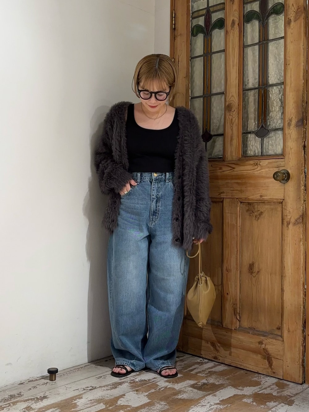 ブルー系のデニムパンツ、グレー系のカーディガン/ボレロ、ブラウン系のショルダーバッグを着用したレディースの秋コーディネートの2枚目の写真