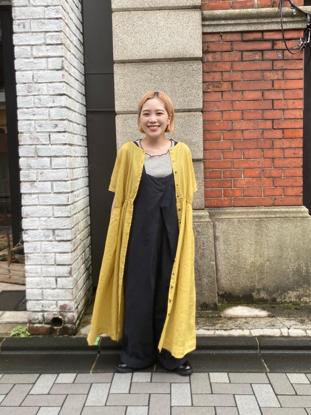 ブルー系のサロペット/オーバーオール、ブラック系のローファー、イエロー系のワンピースを着用したレディースの夏コーディネートの2枚目の写真
