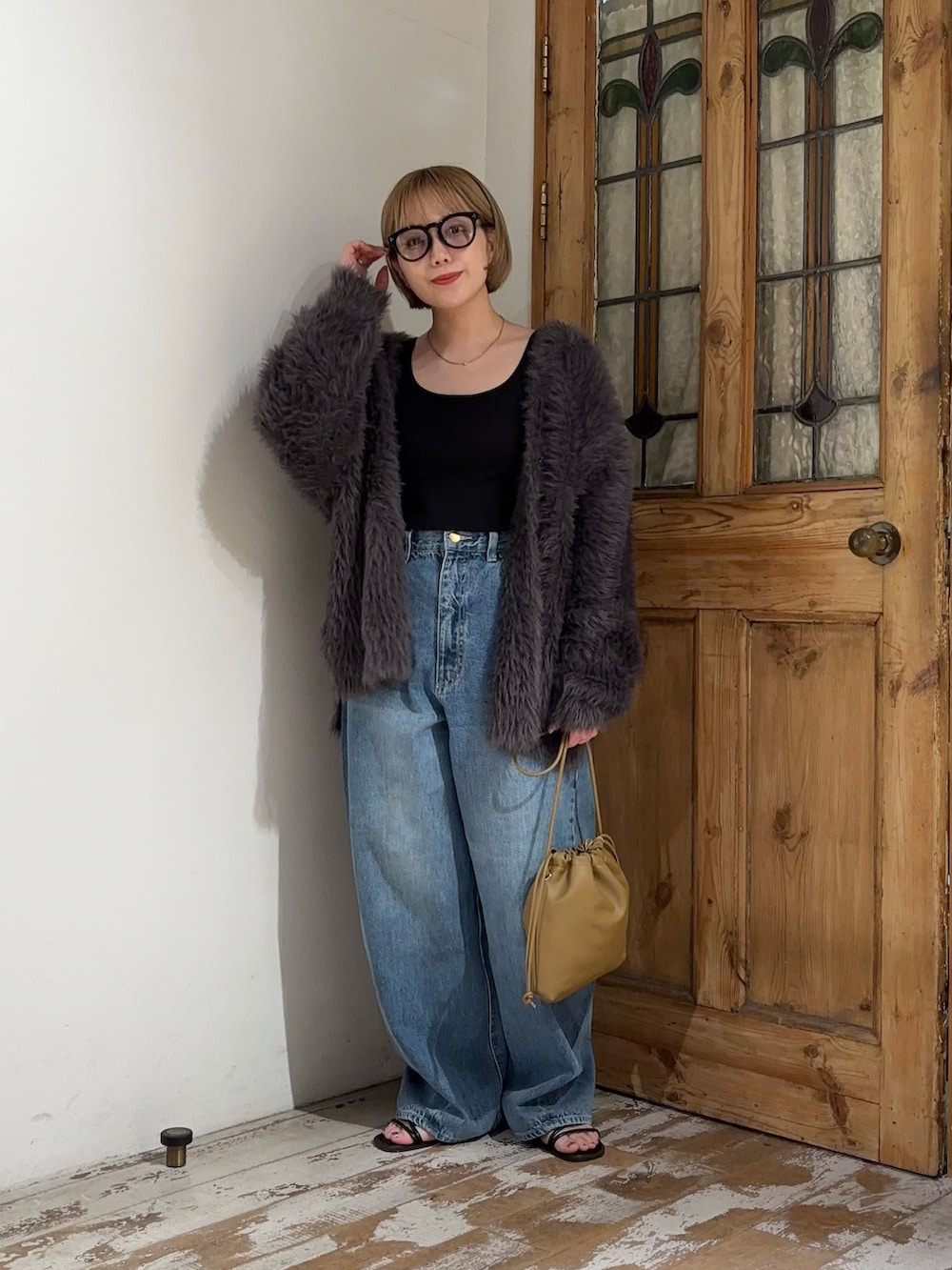 ブルー系のデニムパンツ、グレー系のカーディガン/ボレロ、ブラウン系のショルダーバッグを着用したレディースの秋コーディネートの3枚目の写真