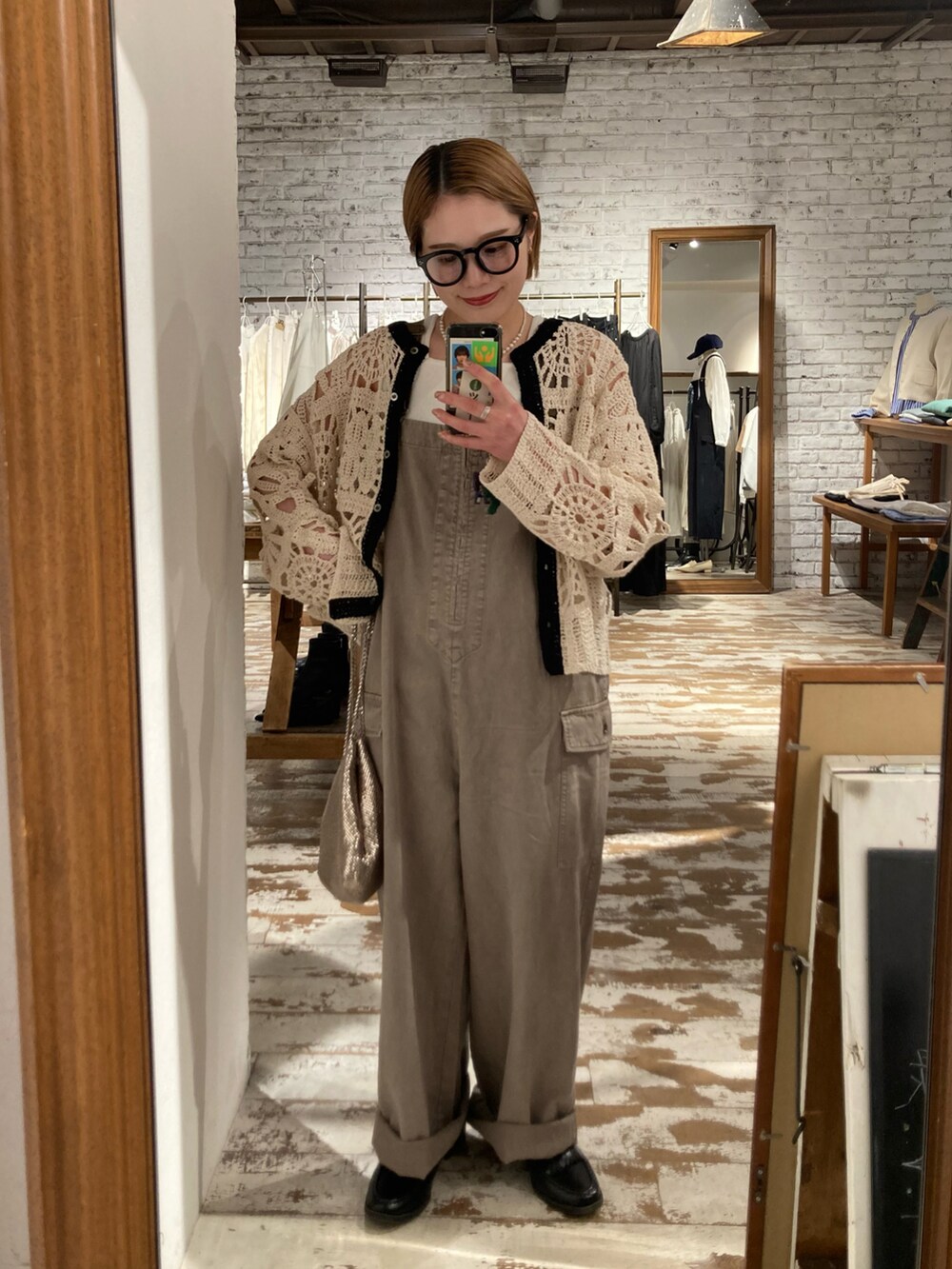 ブラック系のローファー、ゴールド系のショルダーバッグ、ベージュ系のサロペット/オーバーオールを着用したレディースの春コーディネートの3枚目の写真