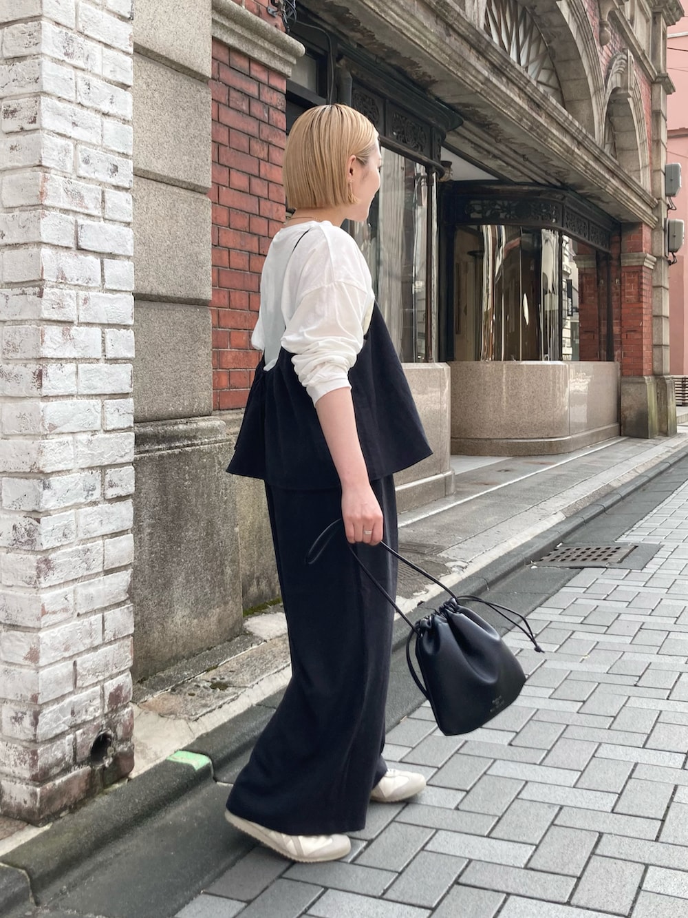 ブラック系のショルダーバッグ、ブラック系のつなぎ/オールインワン、ホワイト系のTシャツ/カットソーを着用したレディースの秋コーディネートの2枚目の写真