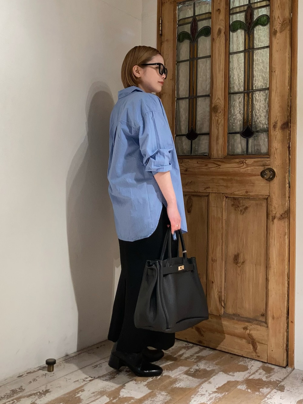 ブラック系のボストンバッグ、ブラック系のブーツ、ブラック系のスカートを着用したレディースの春コーディネートの4枚目の写真