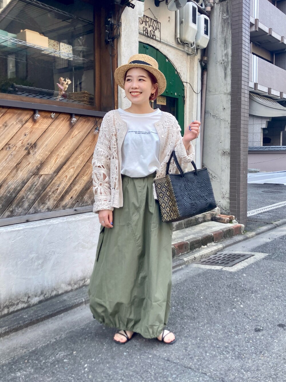 ベージュ系のカーディガン/ボレロ、ホワイト系のTシャツ/カットソー、グリーン系のスカートを着用したレディースの夏コーディネートの4枚目の写真