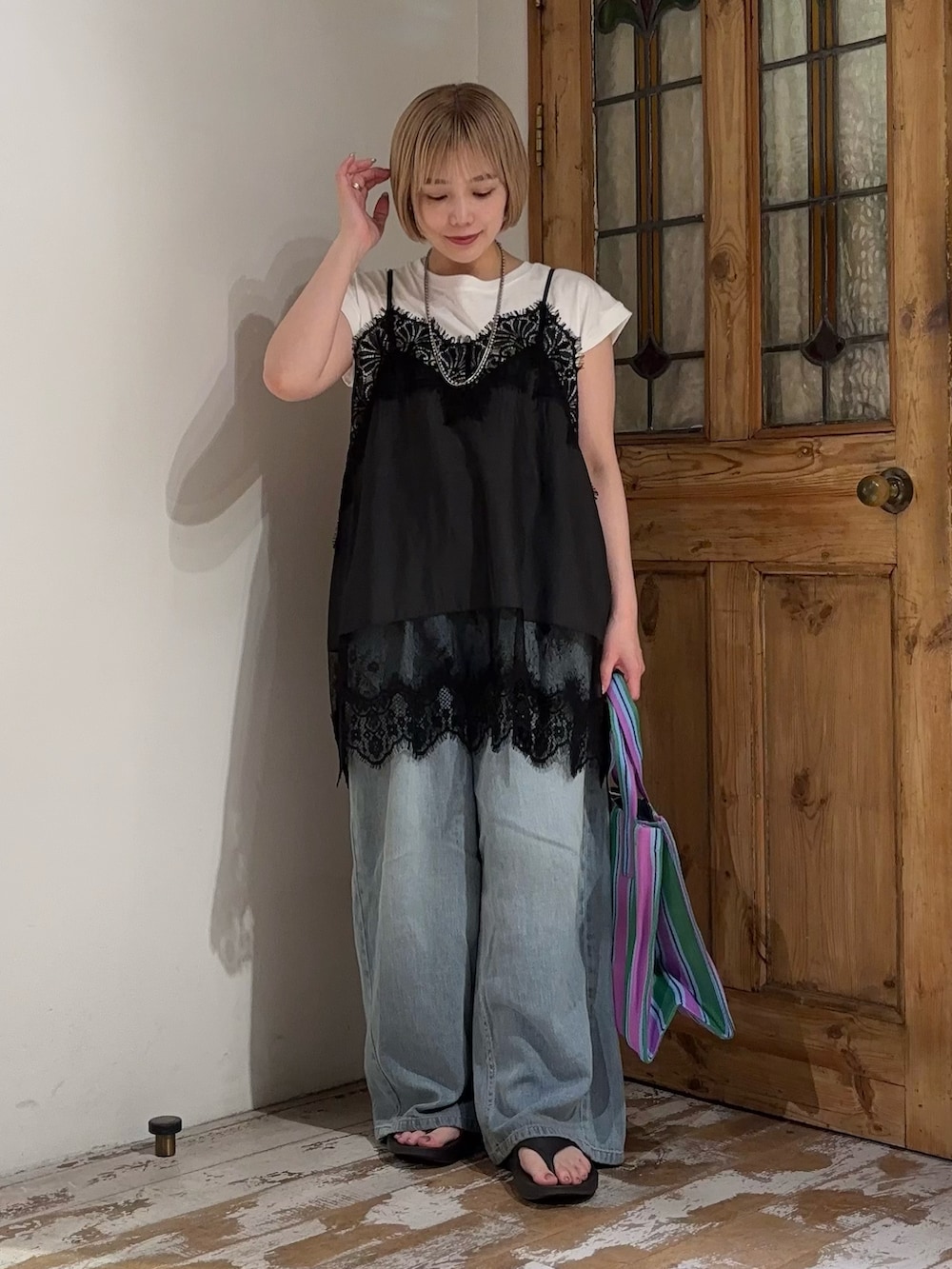 ブルー系のデニムパンツ、ブラック系のキャミソール、ホワイト系のTシャツ/カットソーを着用したレディースの夏コーディネートの2枚目の写真