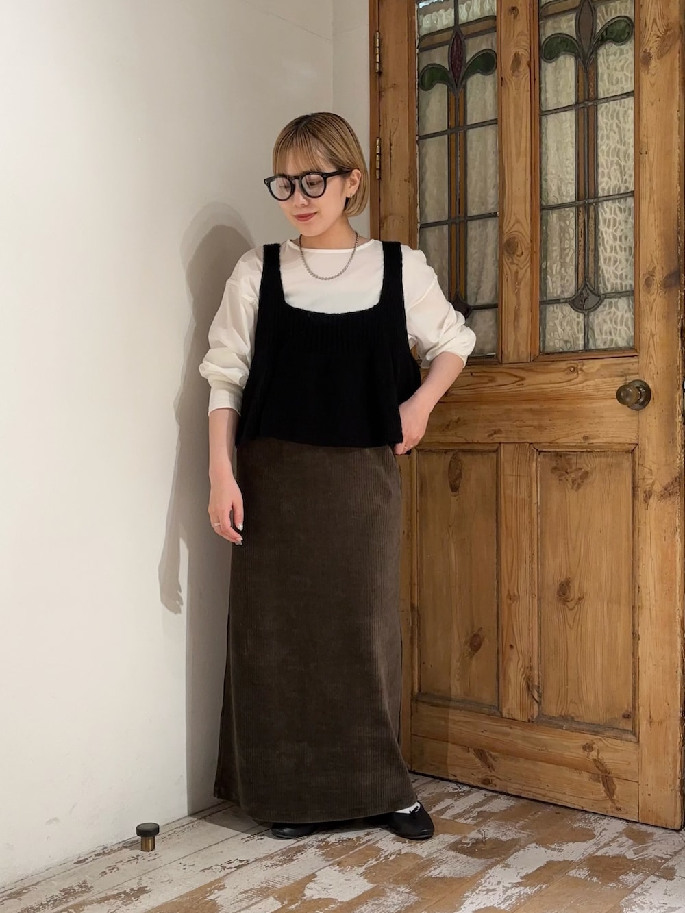 グリーン系のスカート、ブラック系のベスト、ホワイト系のシャツ/ブラウスを着用したレディースの夏コーディネートの2枚目の写真