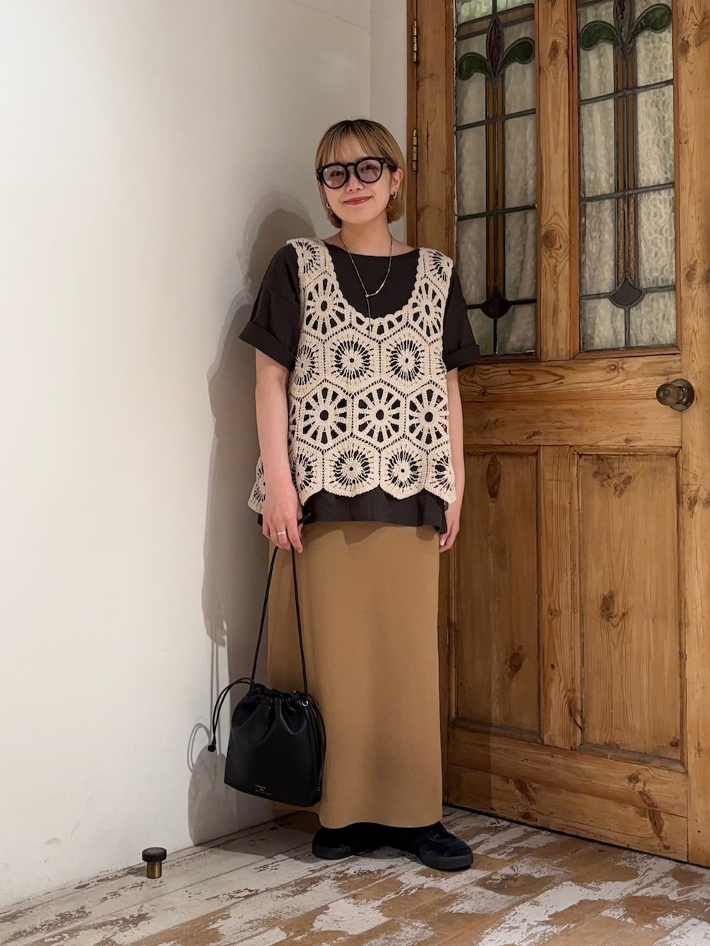 ベージュ系のベスト、グレー系のTシャツ/カットソー、ベージュ系のスカートを着用したレディースの夏コーディネートの2枚目の写真