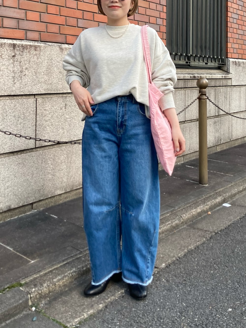 ブラック系のブーツ、ブルー系のデニムパンツ、ピンク系のバッグを着用したレディースの冬コーディネートの4枚目の写真