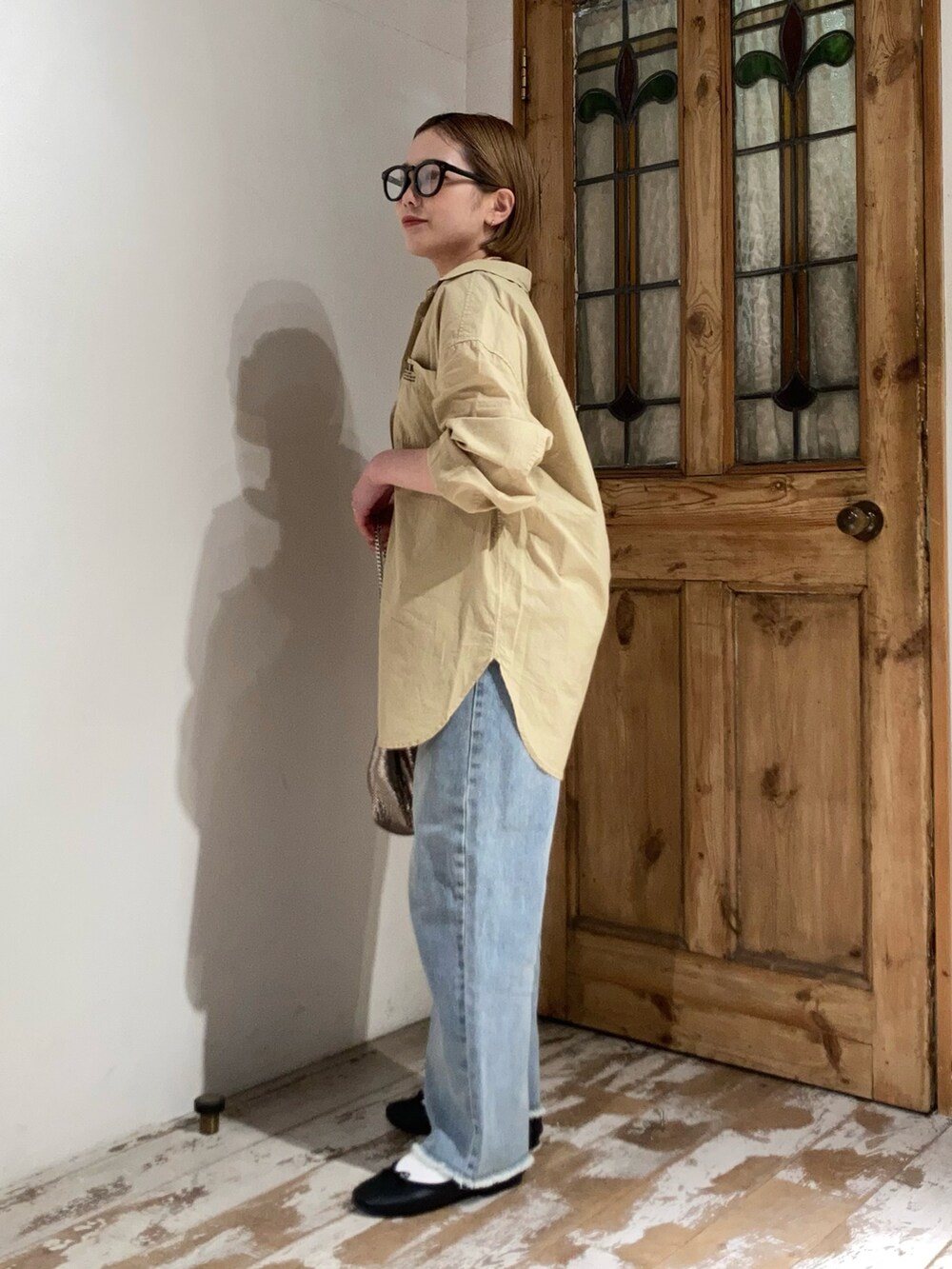 ゴールド系のショルダーバッグ、ブルー系のデニムパンツ、イエロー系のシャツ/ブラウスを着用したレディースの春コーディネートの4枚目の写真