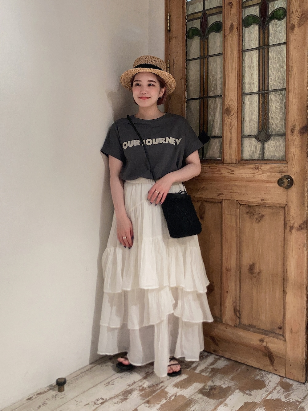 グレー系のTシャツ/カットソー、ホワイト系のスカート、ブラック系のサンダルを着用したレディースの夏コーディネートの2枚目の写真