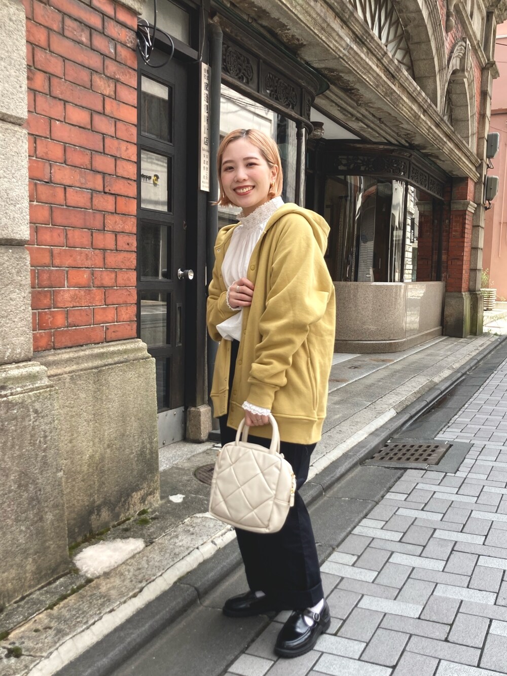 イエロー系のカーディガン/ボレロ、ブラック系のその他パンツ、ホワイト系のシャツ/ブラウスを着用したレディースの夏コーディネートの3枚目の写真