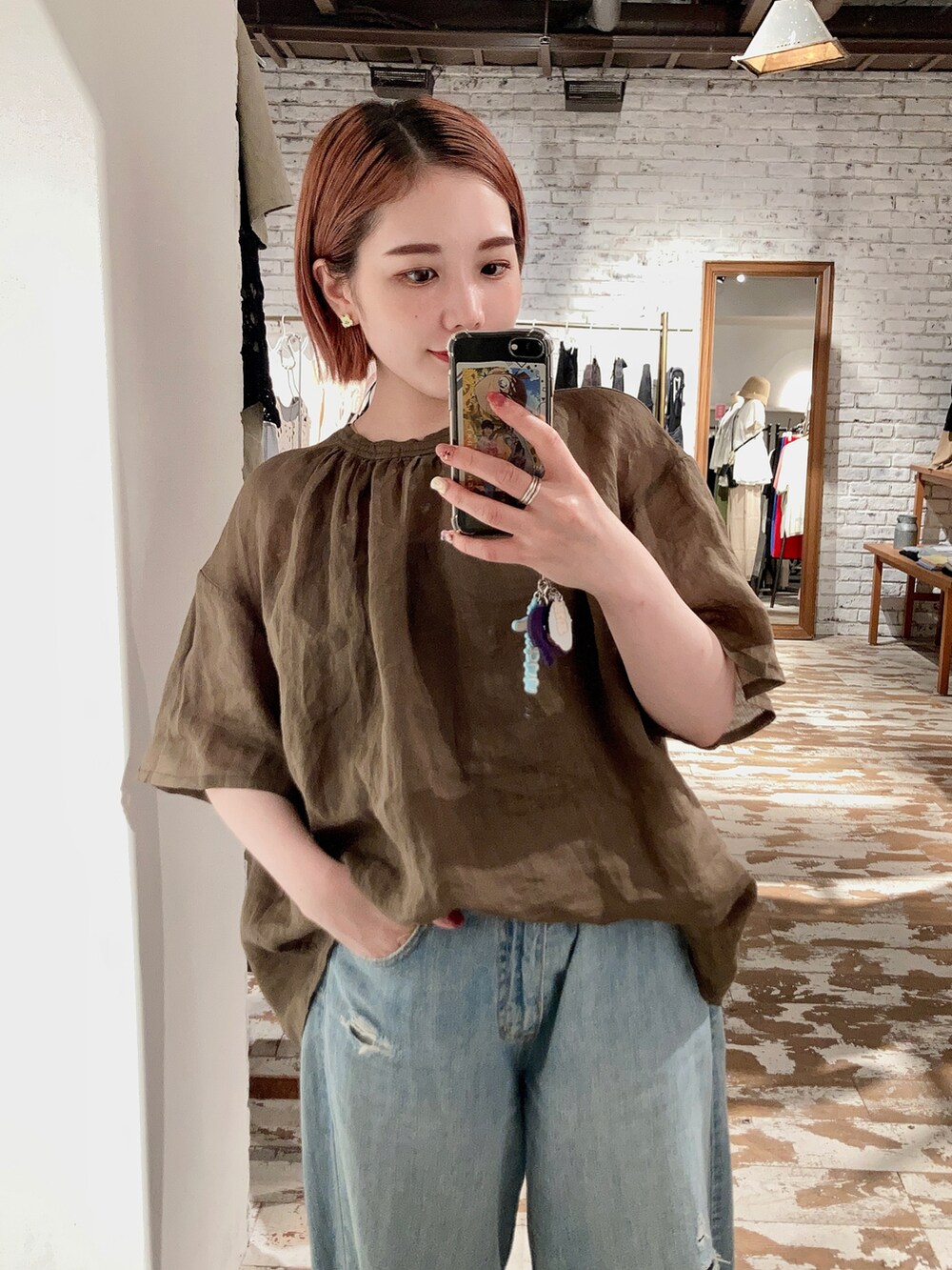 グリーン系のシャツ/ブラウス、ブルー系のデニムパンツを着用したレディースの夏コーディネートの2枚目の写真