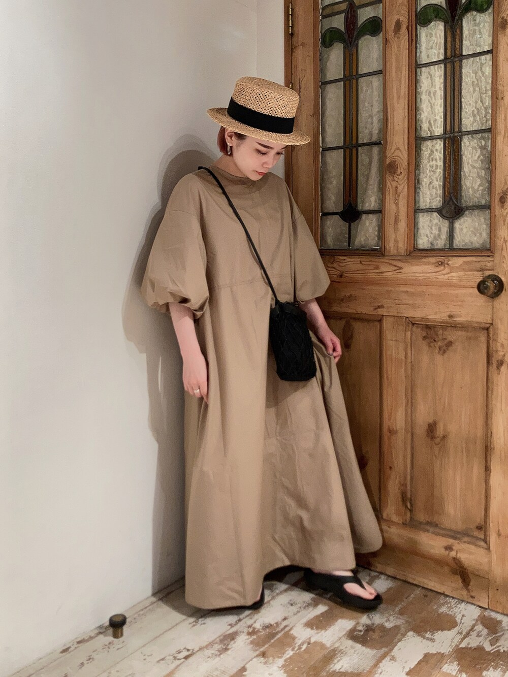 ベージュ系のワンピース、ブラック系のショルダーバッグ、ブラック系のサンダルを着用したレディースの夏コーディネートの2枚目の写真