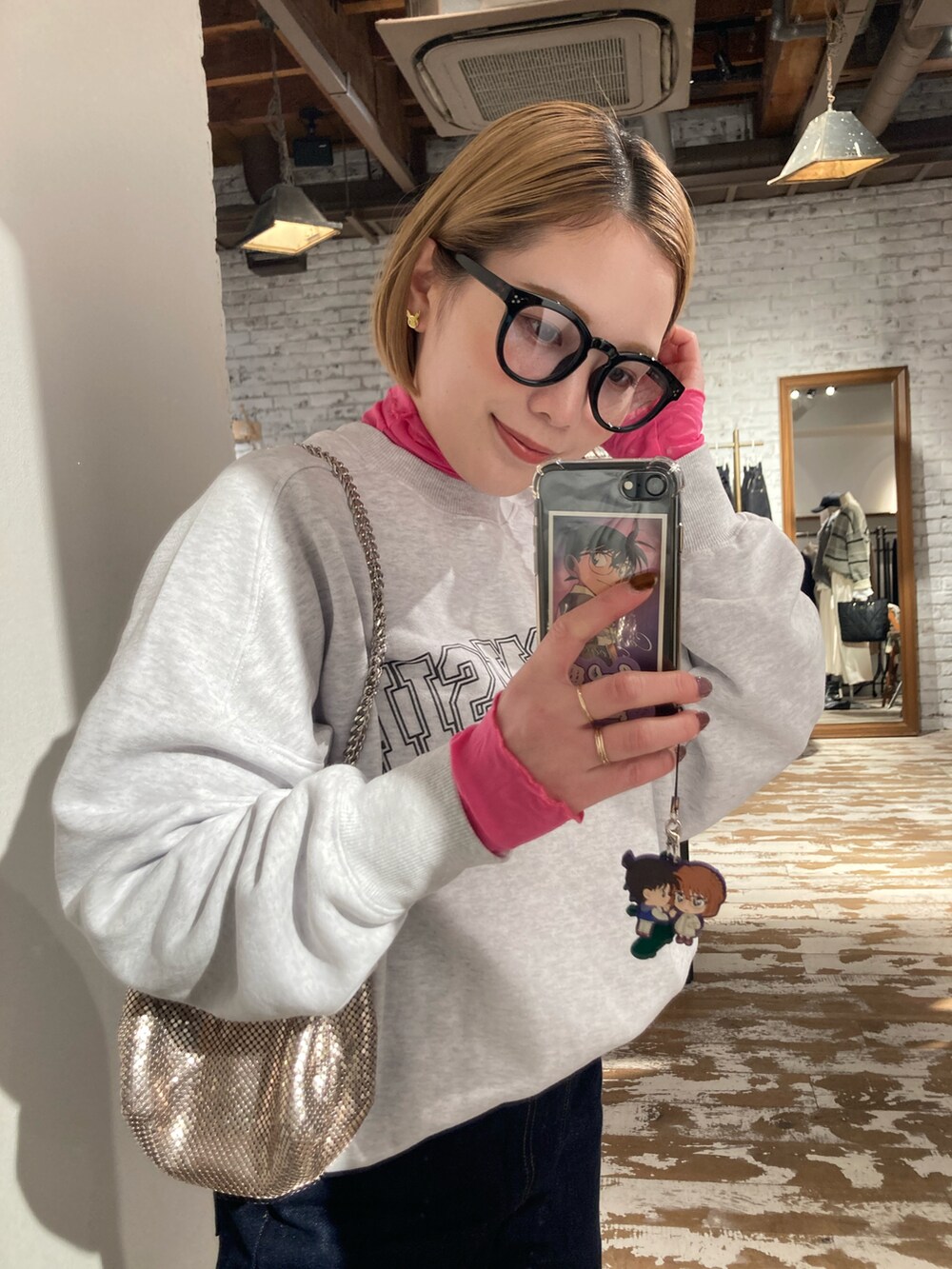 ゴールド系のショルダーバッグ、グレー系のスウェット、ピンク系のTシャツ/カットソーを着用したレディースの冬コーディネートの5枚目の写真